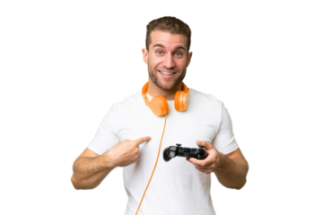 Young handsome man playing with a video game controller isolated on green chroma background with surprise facial expression