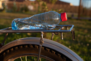 A bottle of water on the bike trunk. Road bike wheel close-up. The concept of a healthy and...
