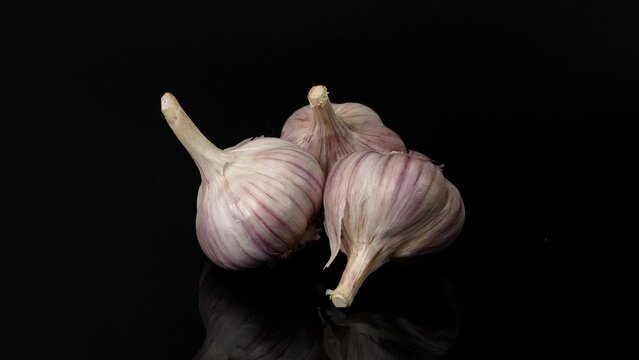 spining garlic on the black background, garlic on the black , close-up of garlic, garlic rotating on a black  background