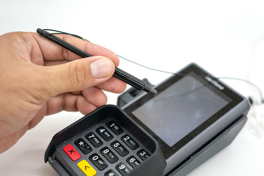 People hand is using digital pen to signing on the credit card reader screen during transaction the payment. Business and technology action, selective focus.