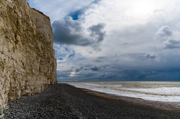 Fototapeta na wymiar black rock beach on the Jurassic Coast of England with tall chalkstone cliffs