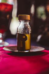 Soft focus. Road opener oil elixir with an old key inside the bottle. Ancient Hoodoo recipe used for spells and rituals to open new doors, remove blockages. Magical potion on a small copper plate.