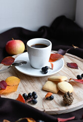 Autumn still life with a cup of coffee, cookies and burgundy leaves