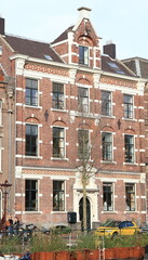 Amsterdam Kloveniersburgwal Canal Street View with Historic Brick Building, Netherlands