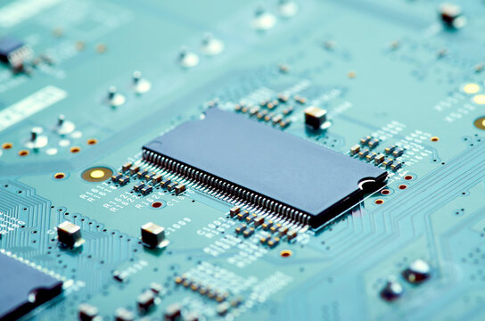 high-tech microchip on an electrical circuit board close-up, soft focus