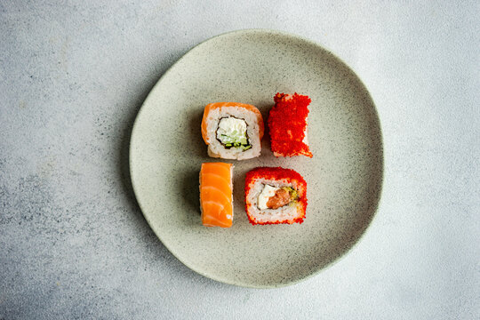 Overhead view of four Japanese maki rolls on a plate
