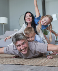 Photo of four members adopted family lying floor toothy smiling fluffy carpet cozy apartments