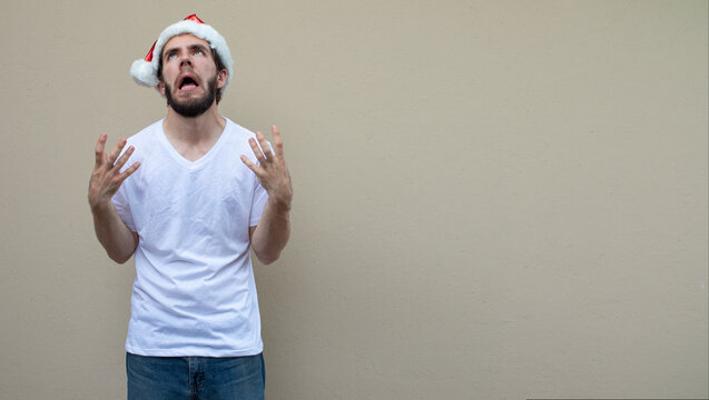 stressed young man worried making gestures with his hands with anxiety wearing a christmas hat anxious of pressure
