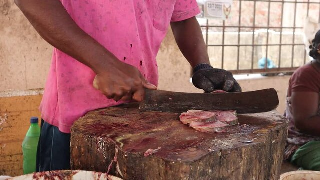 Fish cutting skill at the Indian fish market. An unidentified man's hand slicing a fish at a fish market.