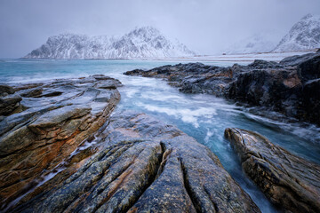 Waves and rocks on coast of Norwegian sea in fjord. Skagsanden beach, Flakstad, Lofoten islands, Norway. Long exposure motion blur