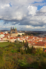 Fototapeta premium Autumn Prague City with gothic Castle, colorful Nature and Trees with dramatic Sky from the Hill Petrin, Czech Republic