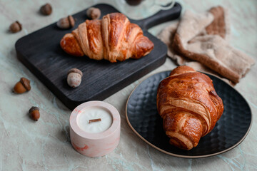 Delicious crispy croissant with chocolate with a cup of invigorating coffee on a light concrete background
