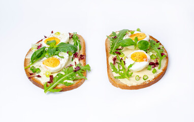 Bruschetta with boiled egg and arugula. Isolated on a white background.