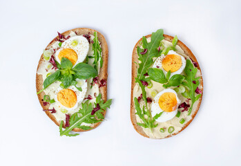 Bruschetta with boiled egg and arugula. Isolated on a white background.