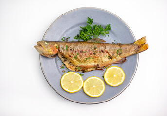 Baked trout with potato in plate. Isolated on white background.