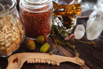 Soft focus background. Occult altar with crystals, herbs and old bone. Medicinal plants in vintage...