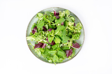 Green lettuce salad with fresh mixed vegetables isolated on white background. Top view, flat lay.