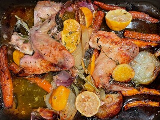 Overhead view of roasted chicken wings, carrots, onions, orange, thyme and sage to make a gravy
