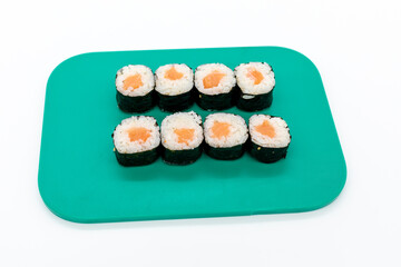Salmon maki sushi on cutting board on white background