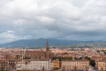 Fototapeta premium Amazing European town with vintage houses and a cathedral near the mountain on a cloudy day. Beautiful Florence