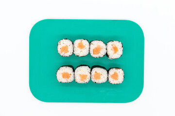 Salmon maki sushi on cutting board on white background
