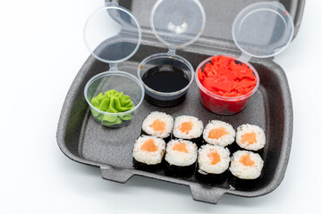 Salmon maki sushi in delivery box on white background
