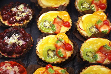 Cakes with fresh fruits and berries, selective focus. Sweet dessert with strawberry, peaches, kiwi and cherry