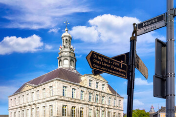 Fototapeta na wymiar Maastricht, Netherlands. Town hall with direction arrows in foreground