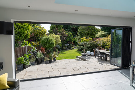 Beautiful garden and patio in summer through bifold doors.