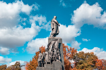 Taras Shevchenko Monument in sunny Kharkiv city center park. Autumn vibes and epic blue sky with white clouds in Shevchenko City Garden, Ukraine - obrazy, fototapety, plakaty