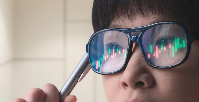 Female crypto trader analyzing online trading stock market chart with reflection on glasses surface, close up with copy space