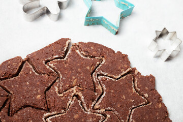 Rolled out chocolate cookie dough on parchment paper. Gluten free almond flour chocolate cookie. Xmas cookie baking background. Swiss recipe 