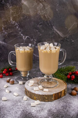 Christmas drink, cocoa with marshmallows on a dark concrete background with garland lights. A concept for holiday recipes and a winter menu. Festive mood new year, copy space for text