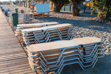 Empty beach with stacked sun loungers on the beach. Crete Greece. High quality photo