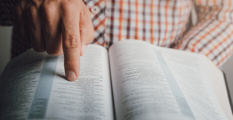 Man reading the bible pointing the text