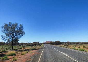 Road surrounded by fields under blue sky in Australia