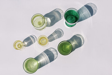 multi-colored green and yellow glass goblets and glasses filled with water. Air bubbles in liquid....