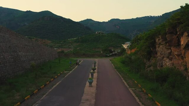 Aerial footage of an empty road in Margalla Hills in Islamabad, Pakistan, with lush green nature