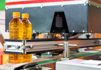 plastic bottle after filling yellow liquid like oil on belt conveyor for move to manufacturing next process in industrial