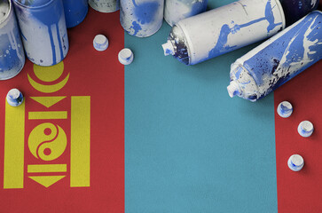 Mongolia flag and few used aerosol spray cans for graffiti painting. Street art culture concept