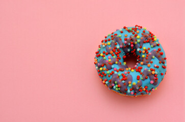 Fototapeta na wymiar donut with blue icing isolated on on a pink background, copy space