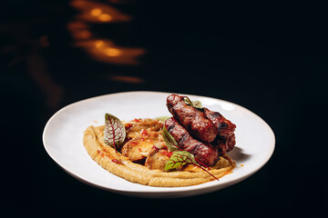 Fried sausages on a vegetable pillow, with sweet and sour sauce. Restaurant service.