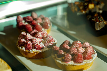 Round cakes with raspberries and powdered sugar