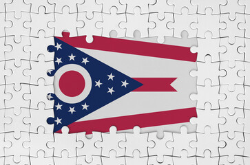 Ohio US state flag in frame of white puzzle pieces with missing central part