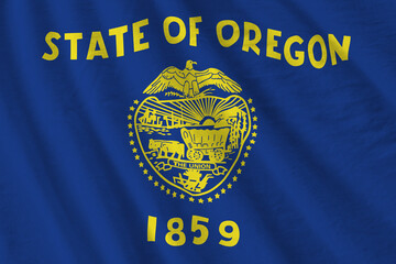 Oregon US state flag with big folds waving close up under the studio light indoors. The official...