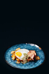 Breakfast with potatoes bacon peppers sweet potatoes cheese and fried egg, top view with copy space.