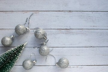 Christmas ornaments on white wooden background Christmas decorations silver balls and Christmas tree on white table. Top view, flat lay, copy space. Winter holiday preparation