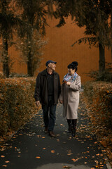 married couple walking in the park in autumn