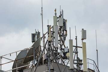 Close up to many antennas on the roof of a construction in an urban area