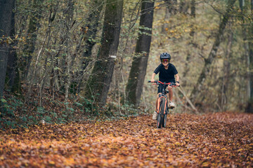 Enfant en vélo dans les bois en automne - obrazy, fototapety, plakaty